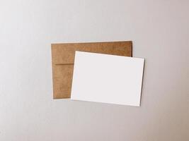 Vide blanc papier carte avec rustique marron enveloppe photo