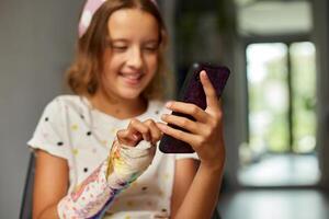 adolescent fille avec une cassé bras orthopédique jeter utilisation téléphone intelligent photo
