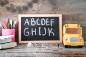 école planche sur une en bois Contexte. des lunettes pour vision correction. photo