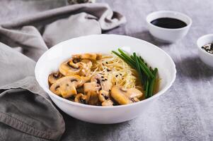 funchoisir riz nouilles avec champignons et vert oignons dans une bol sur le table photo