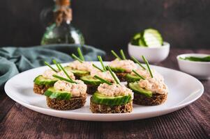 délicieux des sandwichs sur seigle pain avec concombre, capelan caviar et vert oignons sur une assiette photo