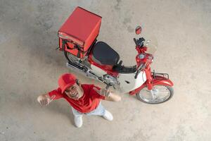 livraison homme avec moto donnant pouce en haut photo