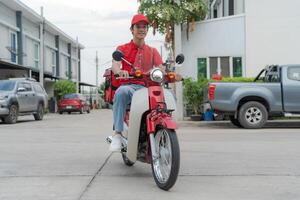 livraison cavalier sur rouge moto avec isolé nourriture boîte garé en plein air photo