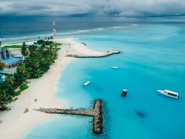 Maldives tropical plage avec jetée et bateaux dans bleu océan. Voyage vacances concept. aérien vue photo