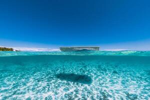 tropical océan l'eau avec sablonneux bas et bateau photo