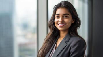 professionnel femme dans affaires costume souriant en toute confiance dans moderne Bureau paramètre, gratte-ciel Contexte photo