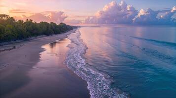 aérien vue de océan vagues s'écraser à le coucher du soleil sur plage photo