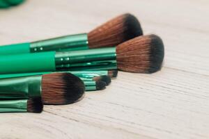 vert maquillage brosses sur une en bois tableau. photo