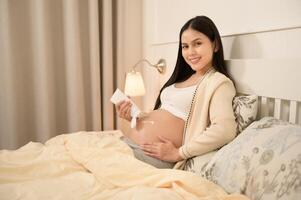 magnifique Enceinte femme appliquant hydratant, étendue marque crème sur ventre, la fertilité infertilité traitement, FIV, futur maternité concept photo