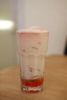 fraise Lait smoothie dans verre sur en bois table Contexte. photo