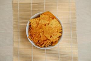 Nachos frites dans une bol sur une bambou napperon photo