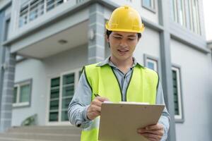 l'inspecteur ou l'ingénieur inspecte la construction et l'assurance qualité de la nouvelle maison à l'aide d'une liste de contrôle. ingénieurs ou architectes ou entrepreneur travaillent pour construire la maison avant de la remettre au propriétaire photo