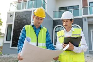 inspecteur ou ingénieur est inspecter construction et qualité assurance Nouveau maison en utilisant une bleu imprimer. ingénieur ou architectes ou contacteur travail à construire le maison avant remise il plus de à le propriétaire photo