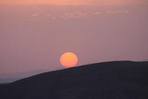 une le coucher du soleil avec des nuages et une Orange Soleil réglage dans le ciel. photo