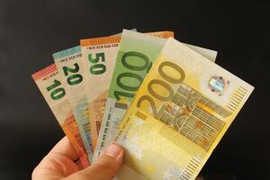 homme compte euro argent avec le sien main. euro billets de banque. le papier devise de européen syndicat .calculatrice dans le Contexte. photo