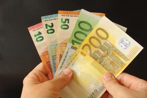 homme compte euro argent avec le sien main. euro billets de banque. le papier devise de européen syndicat .calculatrice dans le Contexte. photo