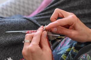 femme mains tricoter une chaussette avec tricot aiguilles. fermer photo