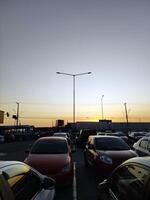 Urbain coucher de soleil, dans le milieu de voitures. assombrir le journée avec électrique fils et silhouette voitures. photo