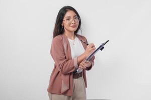 Jeune asiatique affaires femme dans lunettes en portant une document et stylo à écrire rapport, isolé par blanc Contexte. photo
