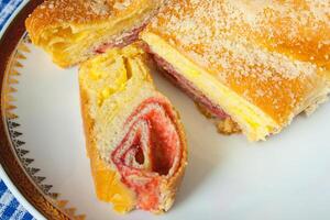 Cerise strudel sur une blanc assiette avec doré bords photo