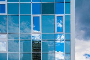 moderne façade de verre et acier reflétant ciel et des nuages photo