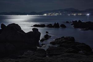 rochers et mer illuminés par la lune photo