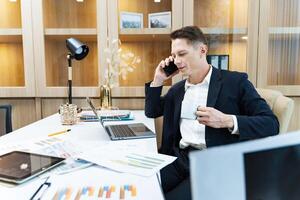 caucasien affaires directeur en utilisant téléphone à appel client tandis que en cours d'analyse le Ventes rapport de commercialisation équipe pour affaires le revenu et financier la gestion concept photo