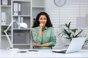 portrait de sérieux en pensant femme à lieu de travail à l'intérieur Accueil bureau, affaires femme en pensant à propos résolution difficile financier problèmes. photo