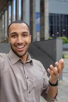 appel, Jeune homme homme d'affaire souriant et à la recherche à caméra, prise selfie photo, ouvrier en marchant autour ville à l'extérieur Bureau bâtiment, en utilisant téléphone intelligent app pour communication, verticale tir. photo