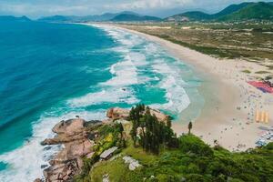 joaquina plage avec rochers et bleu océan avec vagues dans Brésil photo