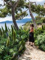 magnifique Jeune femme dans une élégant robe élégamment pose près le bassin à une luxueux villa photo