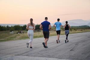 une groupe de copains maintient une en bonne santé mode de vie par fonctionnement en plein air sur une ensoleillé jour, collage plus de aptitude et profiter le énergétique effets de exercice et la nature photo