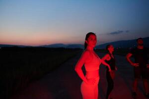 athlète grèves une pose dans allumé en rouge la nuit lueur photo