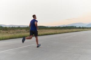 une dévoué marathon coureur pousse lui-même à le limite dans entraînement. photo