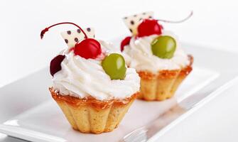 magnifique crème Gâteaux avec cerises et les raisins sur une assiette sur une blanc Contexte photo