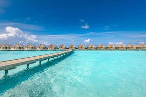île paradisiaque des maldives. paysage aérien tropical, paysage marin avec jetée, villas bungalows sur pilotis avec magnifique plage de lagon de mer. destination touristique exotique, fond de vacances d'été. voyages aériens photo