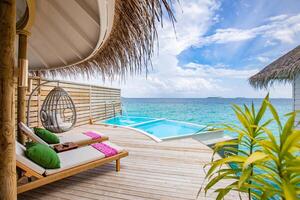 fantastique villa sur pilotis, vue sur la terrasse avec chaises longues sous parasol, hôtel de luxe avec piscine et vue imprenable sur l'océan. beau concept de spa ou de bien-être, zone tranquille de villégiature récréative photo