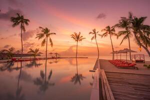 coucher de soleil de luxe en plein air sur la piscine à débordement piscine hôtel en bord de mer d'été, paysage tropical. beau fond de vacances de vacances à la plage tranquille. vue imprenable sur la plage au coucher du soleil sur l'île, palmiers photo