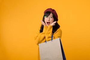 une mode avisé individuel, sportif une rouge béret et Jaune chandail, exulte dans une achats fête contre une vibrant Jaune Contexte. photo