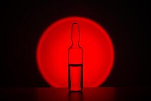 ampoule pour injection contre le Contexte de une brillant rouge cercle. photo