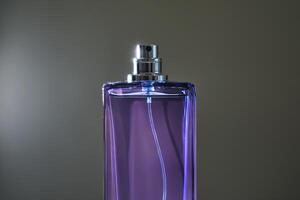 parfum vaporisateur dans une violet bouteille sur une foncé Contexte. photo