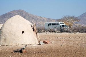 Voyage d'aventure. visite d'une tribu himba, dans la région de kunene, en namibie. les maisons sont faites de terre et de fumier par les femmes himba. photo