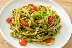 pâtes spaghetti fettuccine avec sauce pesto et tomates photo