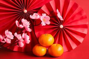 chinois Nouveau année de le dragon Festival concept. mandarin orange, rouge enveloppes et or lingot avec rouge papier Ventilateurs. traditionnel vacances lunaire Nouveau an. photo