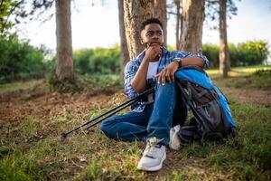 Jeune promeneur fatigué et perdu séance dans le la nature photo