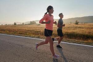 excité par le beauté de nature, une couple pouvoirs par leur Matin courir, leur corps et esprits revigoré. photo