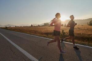 excité par le beauté de nature, une couple pouvoirs par leur Matin courir, leur corps et esprits revigoré. photo