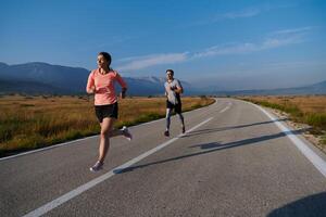 excité par le beauté de nature, une couple pouvoirs par leur Matin courir, leur corps et esprits revigoré. photo