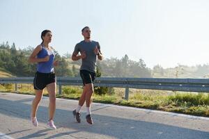 excité par le beauté de nature, une couple pouvoirs par leur Matin courir, leur corps et esprits revigoré. photo