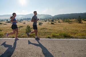 excité par le beauté de nature, une couple pouvoirs par leur Matin courir, leur corps et esprits revigoré. photo